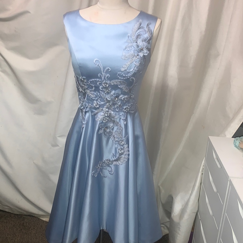 This is a satin dress with a corset bask and a flower detail on the front.